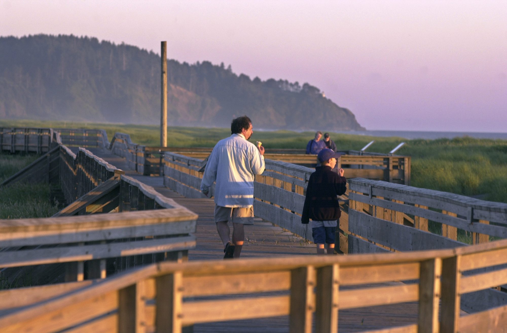 A father and son walk along the Long Beach Boardwalk